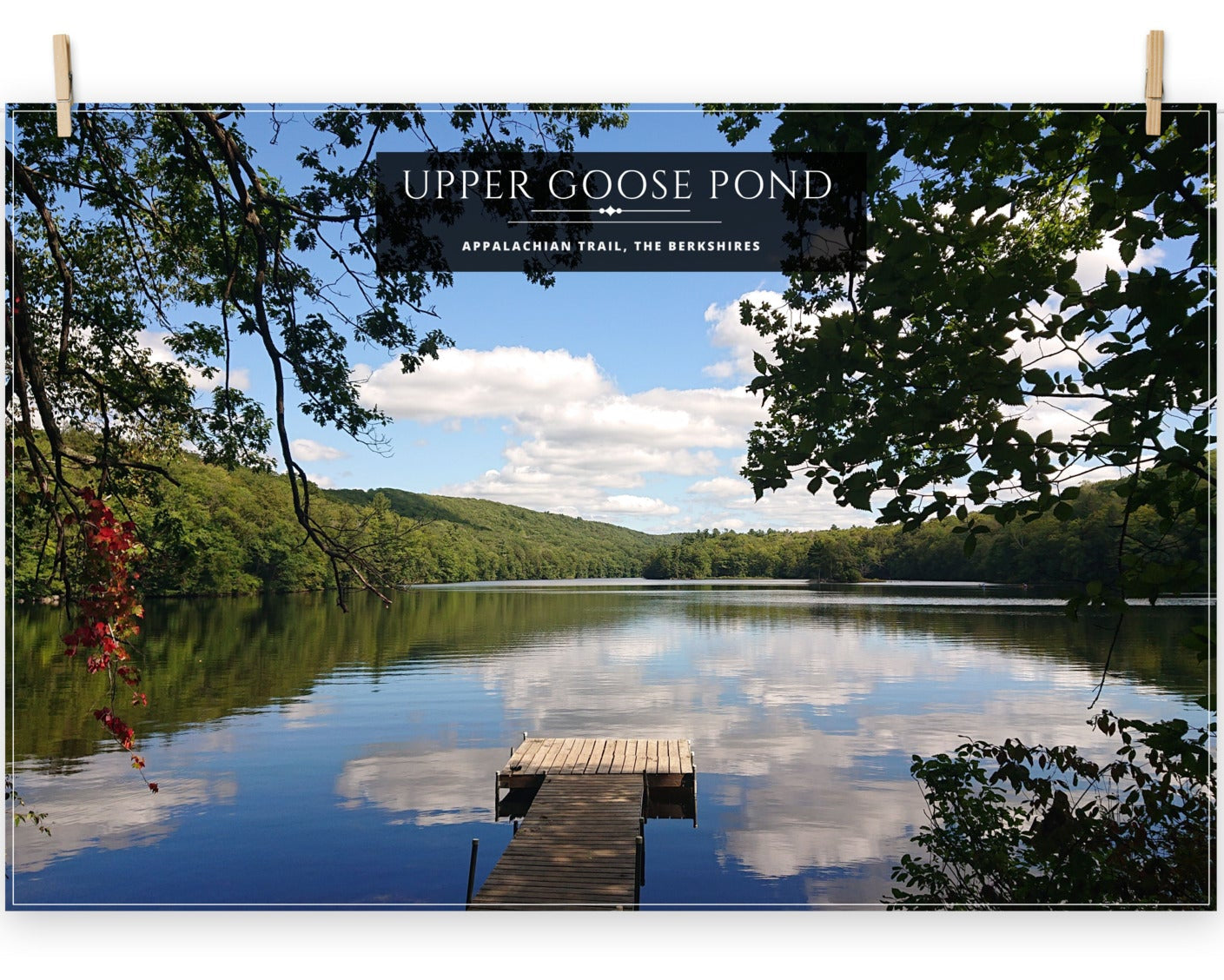 A poster featuring a serene view of Upper Goose Pond with a wooden dock and reflections of clouds in the water.