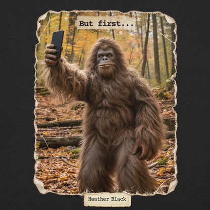 A square graphic print or card featuring a large furry biped creature taking a selfie in a forest with autumn leaves, captioned with the text 'But first.