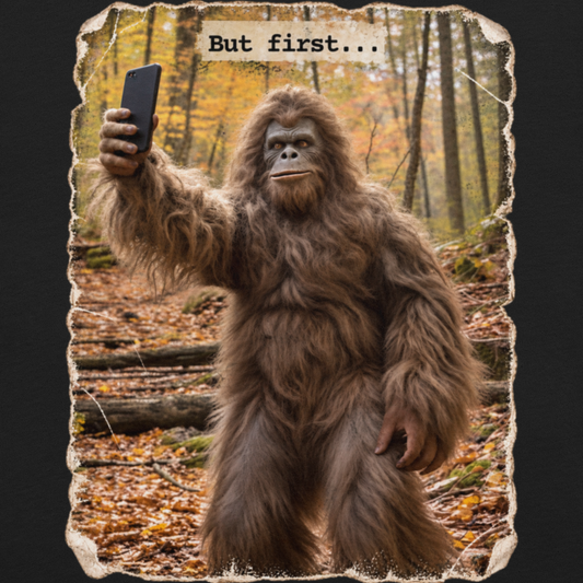 A graphic print featuring a Bigfoot-like creature taking a selfie in a forest with autumn leaves.